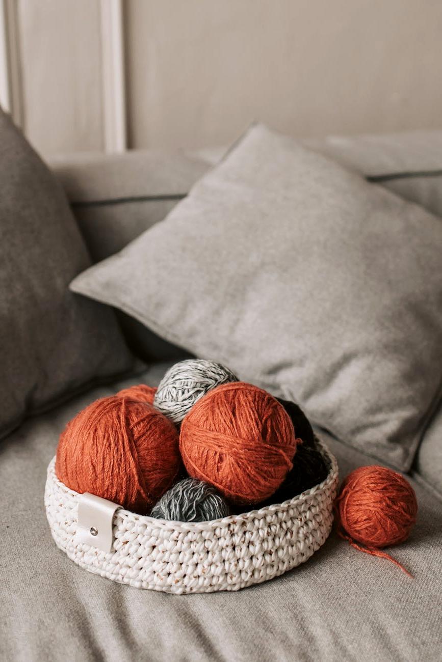Designer knitted cushions with varied patterns arranged on couch