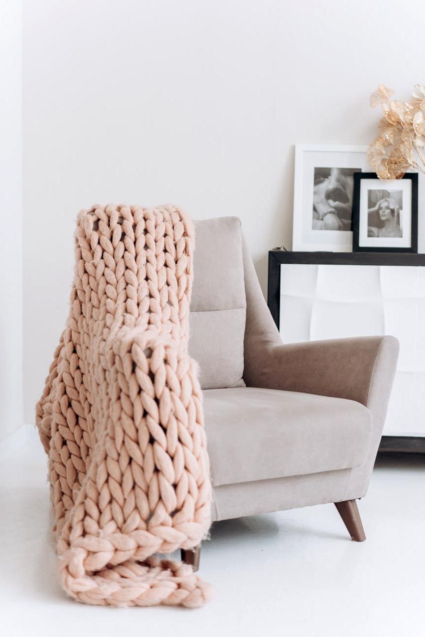 Cozy living room with beautiful knitted throws and pillows creating a warm atmosphere
