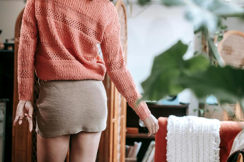 Assortment of handcrafted knitted products including throws, pillows, and wall hangings