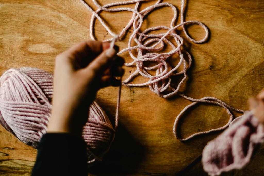Master artisan demonstrating traditional knitting techniques in cozy workshop